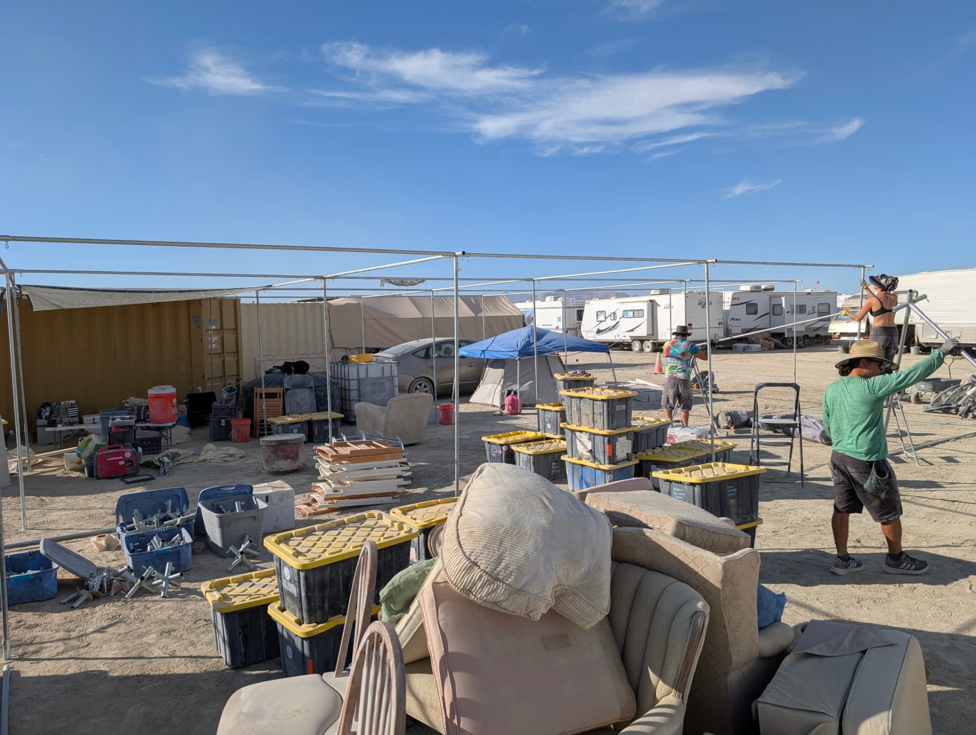 Bare metal shade frame going up beside the camp container