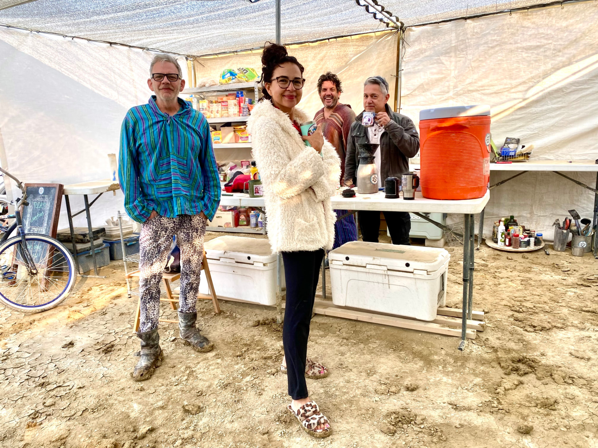 Campers standing around the camp kitchen table with coffee and water coolers